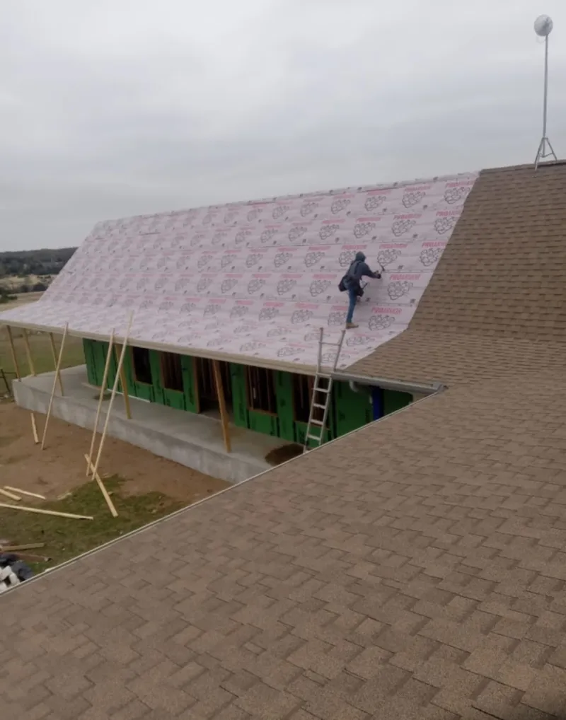 Worker preparing underlayment for a metal roof installation in Seagoville